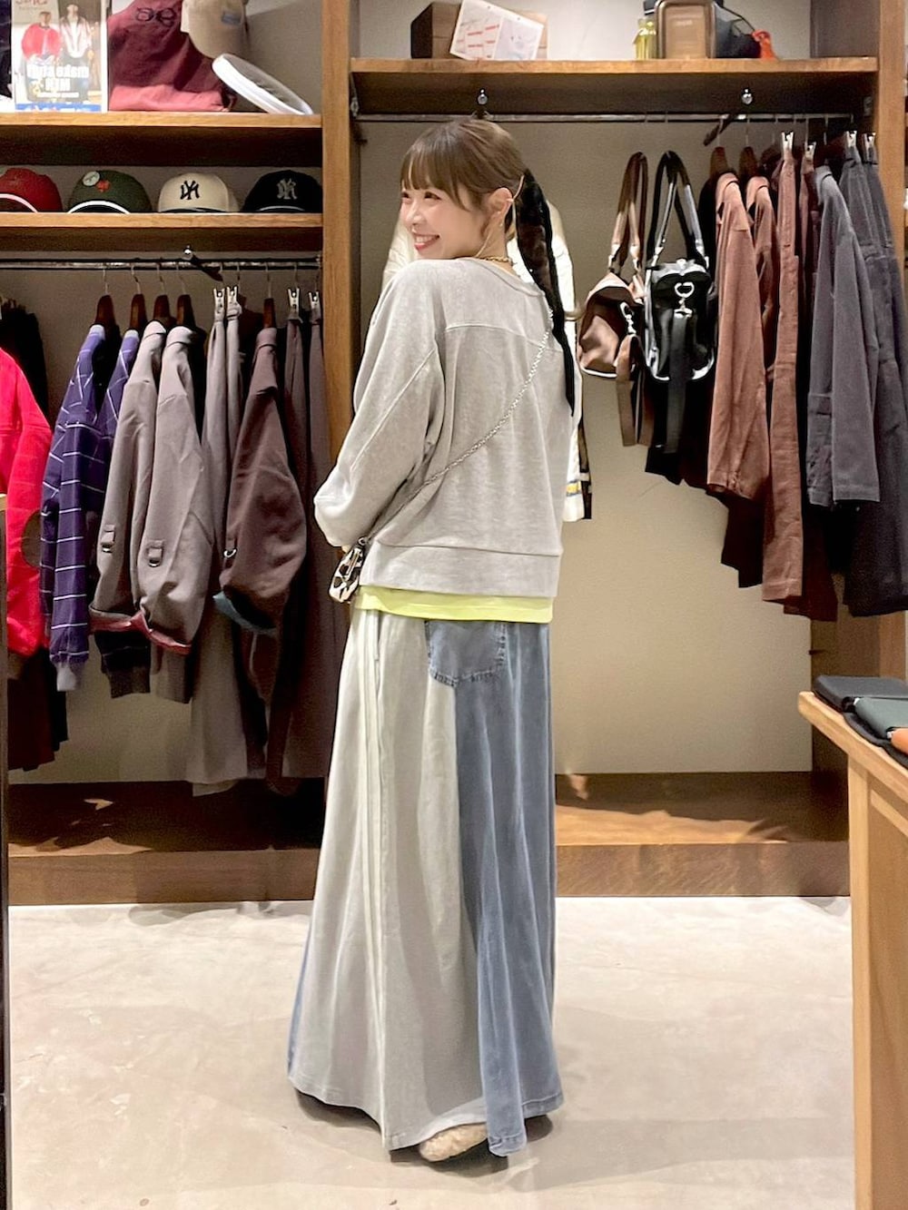 ベージュ系のパンプス、グレー系のスウェット、ブルー系のデニムスカートを着用したレディースの秋コーディネートの5枚目の写真
