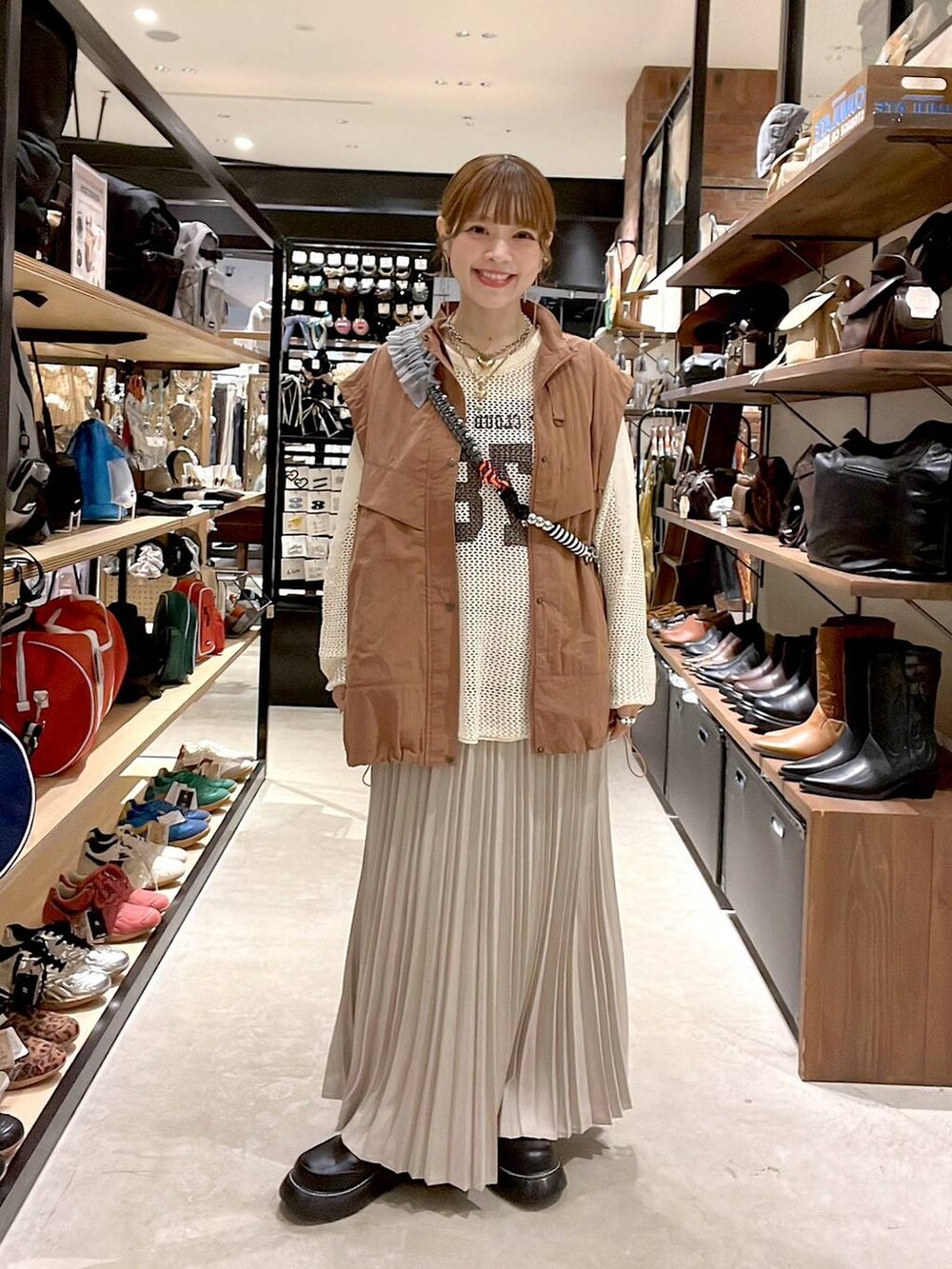 ブラウン系のブルゾン、ブラック系のドレスシューズ、ベージュ系のTシャツ/カットソーを着用したレディースの秋コーディネートの7枚目の写真
