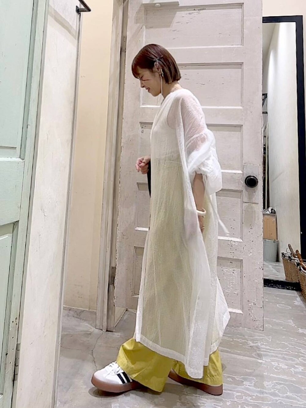 ブルー系のトートバッグ、イエロー系のその他パンツ、ホワイト系のワンピースを着用したレディースの夏コーディネートの5枚目の写真