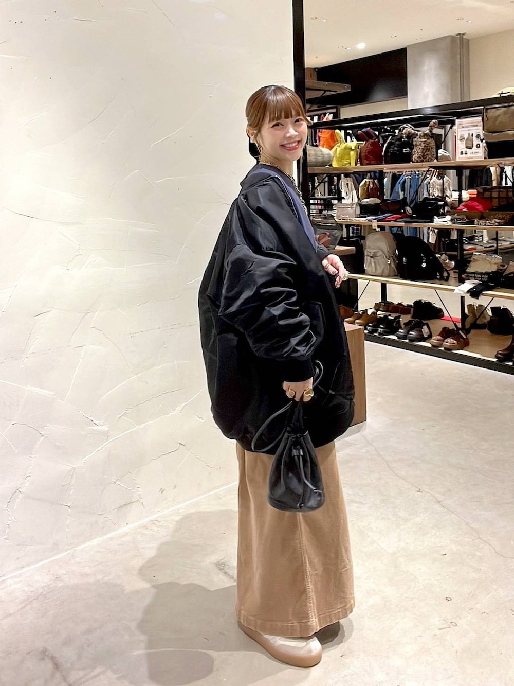 ブラック系のMA-1、イエロー系のスカート、ブルー系のスウェットを着用したレディースの冬コーディネートの3枚目の写真