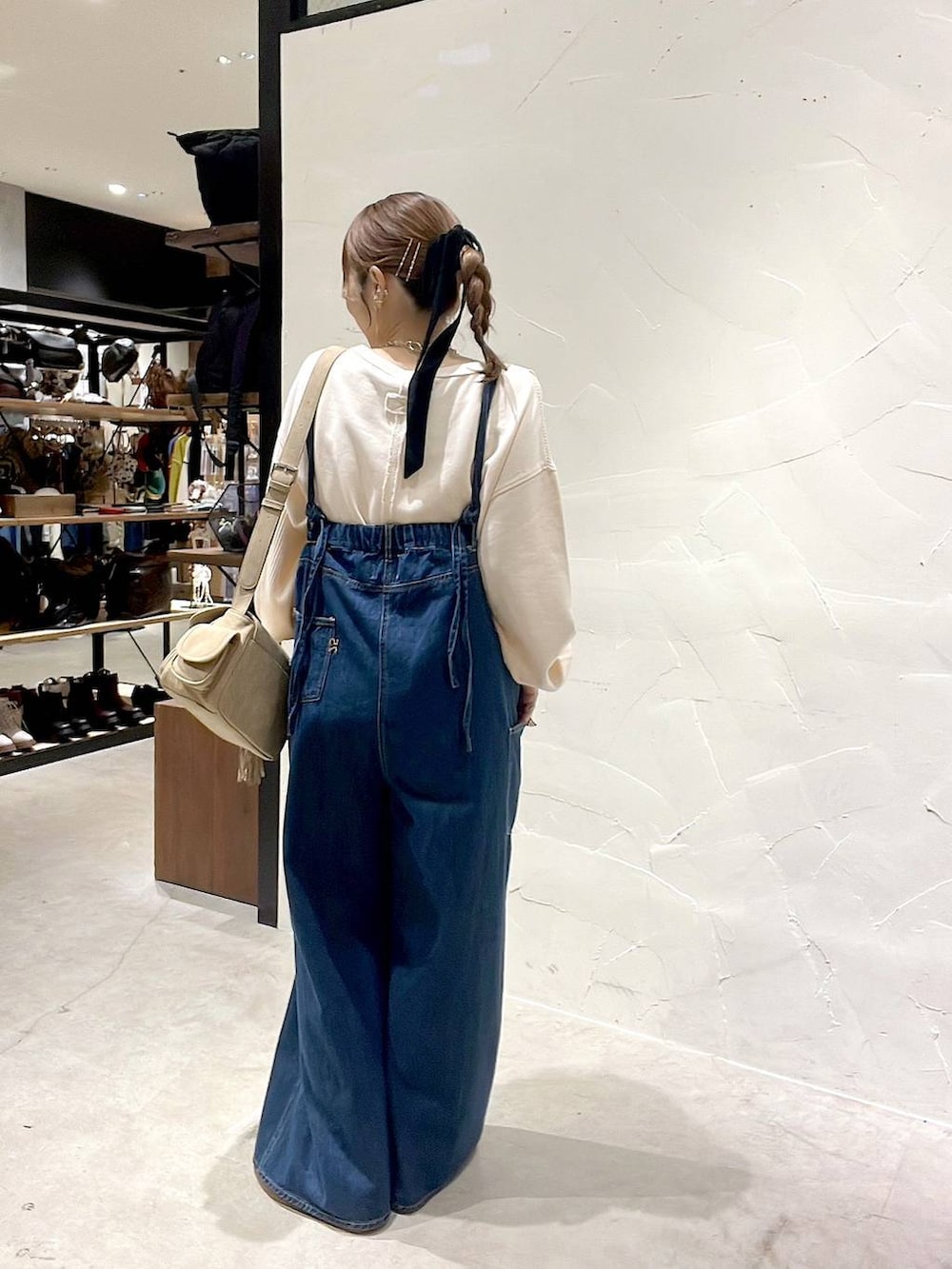 ベージュ系のショルダーバッグ、ブラック系のアナログ腕時計を着用したレディースの秋コーディネートの5枚目の写真