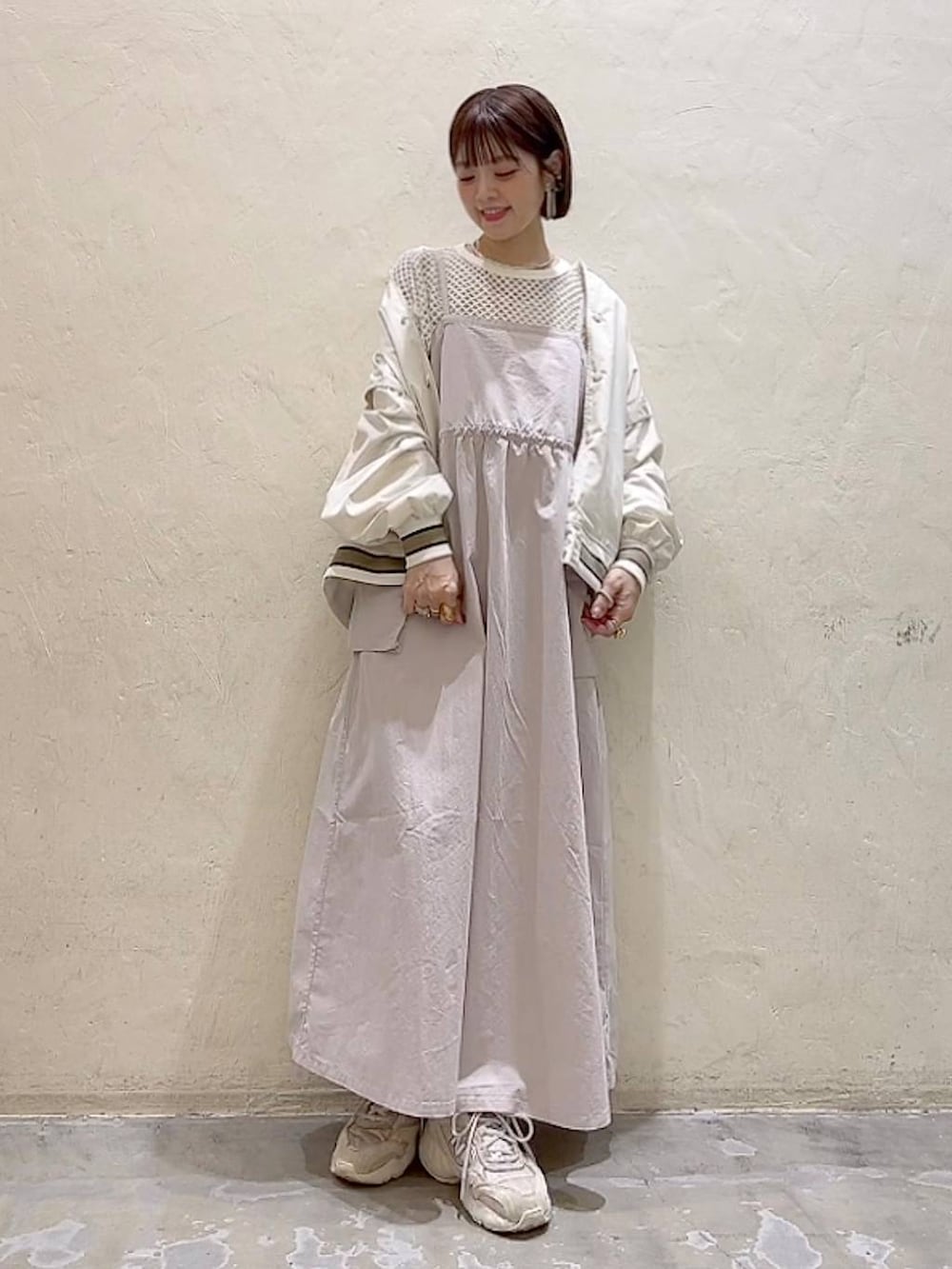ベージュ系のスタジャン、ベージュ系のワンピース、ホワイト系のTシャツ/カットソーを着用したレディースの春コーディネートの6枚目の写真