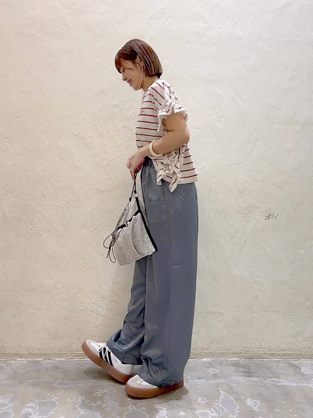 レッド系のTシャツ/カットソー、グレー系のショルダーバッグ、グレー系のその他パンツを着用したレディースの夏コーディネートの5枚目の写真