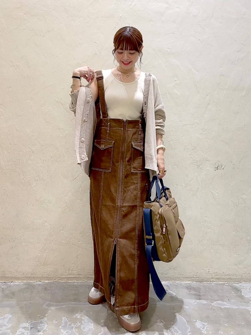 ベージュ系のカーディガン/ボレロ、ブラウン系のスカート、ブラウン系のトートバッグを着用したレディースの秋コーディネートの2枚目の写真