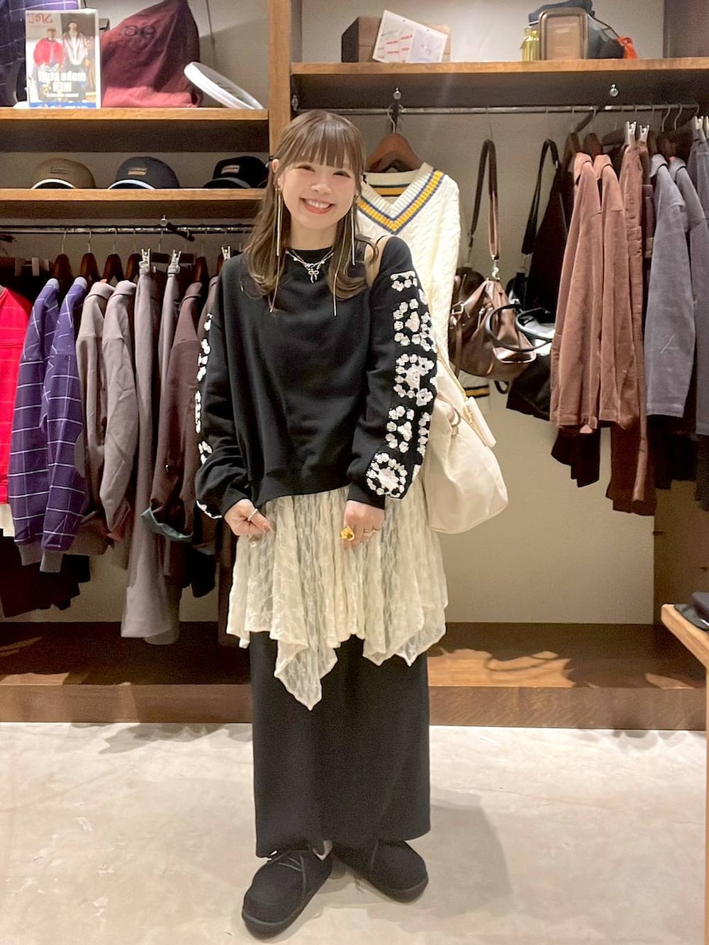 ベージュ系のワンピース、ブラック系のスウェット、ブラック系のモカシン/デッキシューズを着用したレディースの秋コーディネートの7枚目の写真
