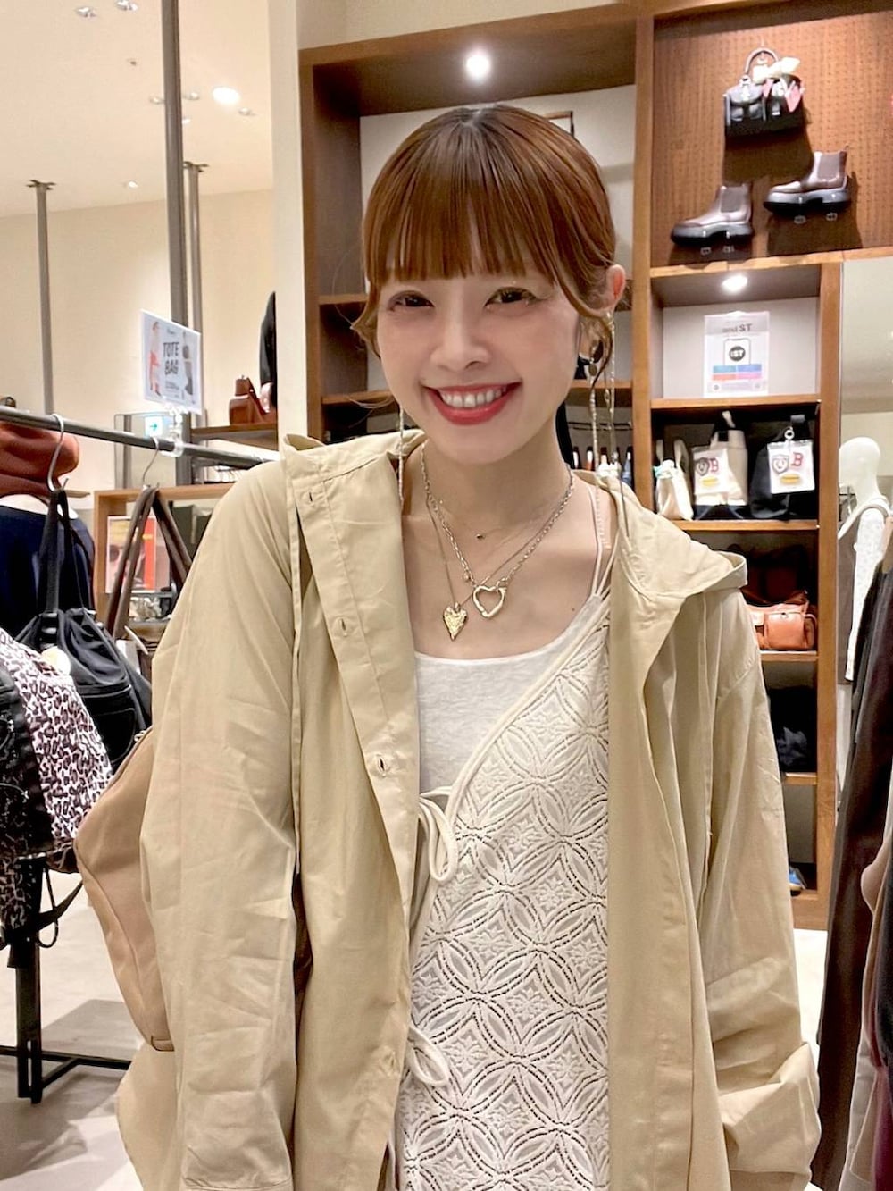 イエロー系のスカート、ベージュ系のボストンバッグ、ベージュ系のワンピースを着用したレディースの秋コーディネートの8枚目の写真