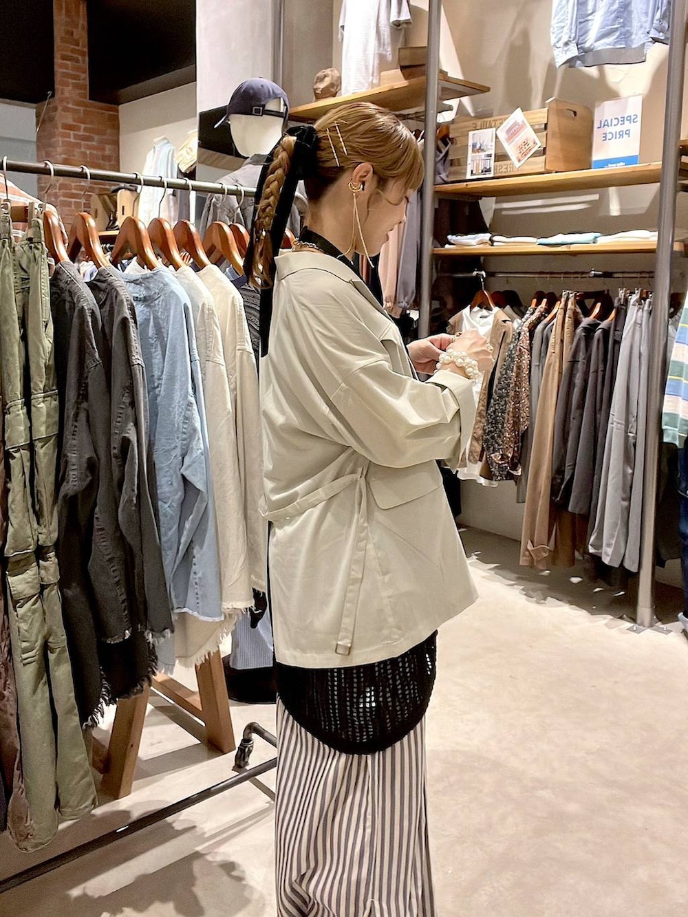 ベージュ系のテーラードジャケット、ブルー系のその他パンツ、ブラック系のワンピースを着用したレディースの春コーディネートの3枚目の写真