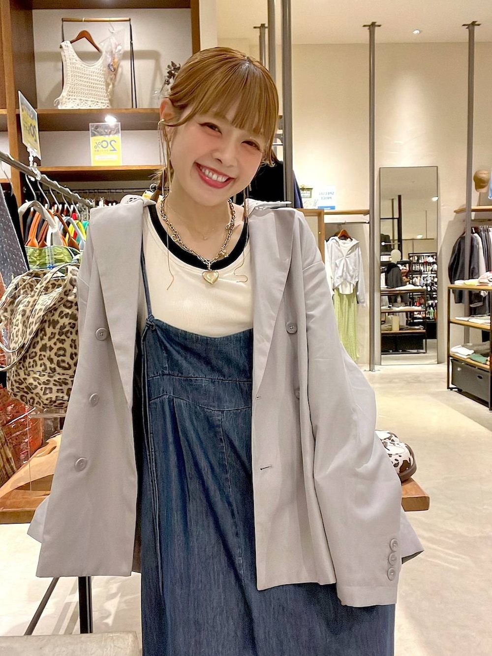 ベージュ系のスニーカー、グレー系のテーラードジャケット、ホワイト系のタンクトップを着用したレディースの春コーディネートの4枚目の写真