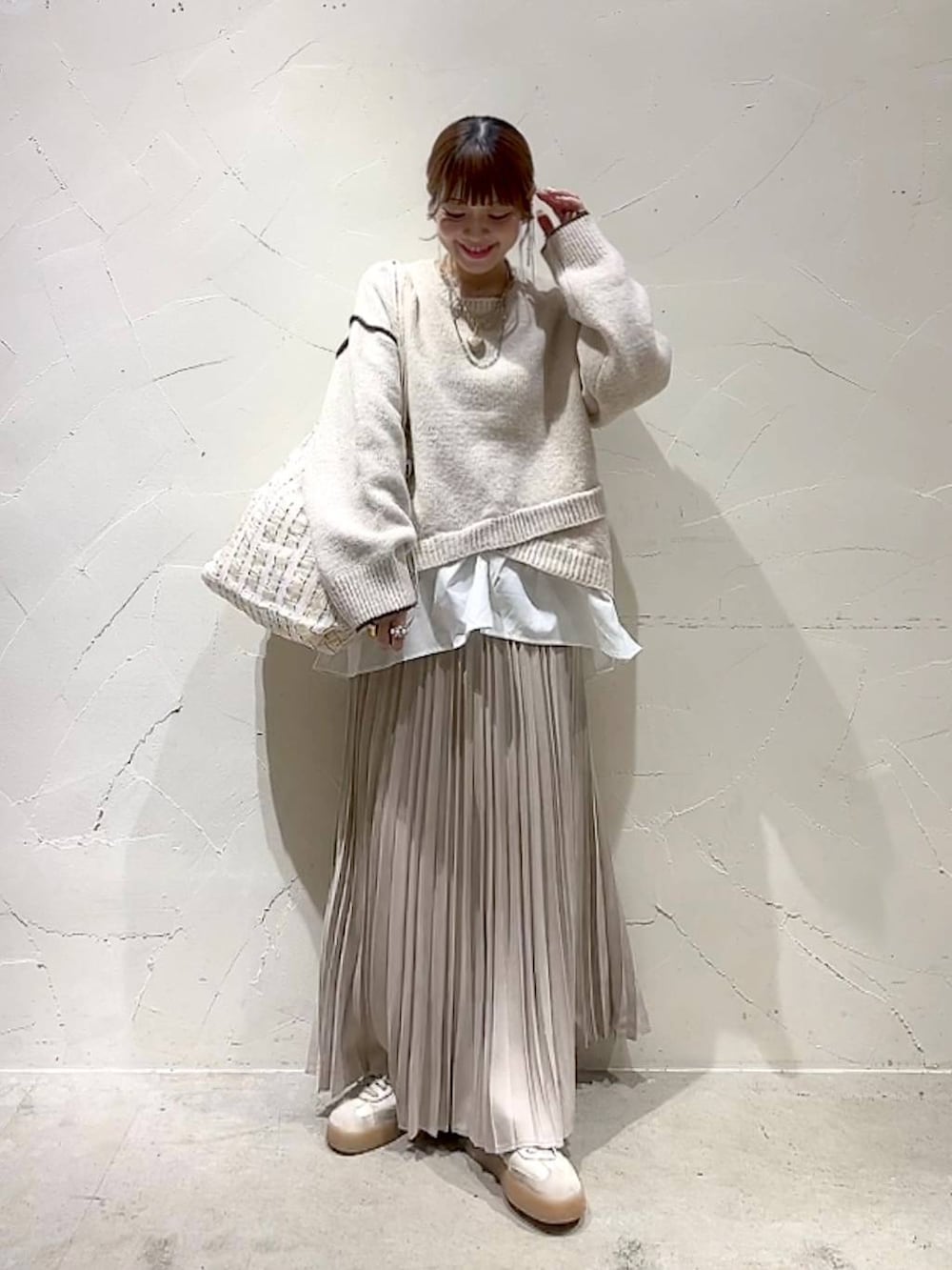 ベージュ系のスカート、その他のトートバッグ、ゴールド系のネックレスを着用したレディースの秋コーディネートの2枚目の写真