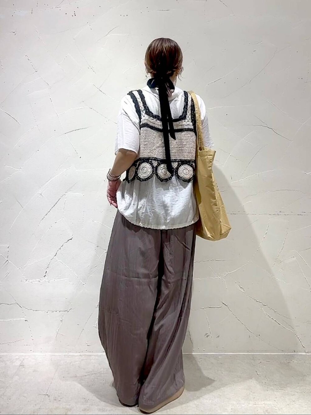 イエロー系のトートバッグ、ホワイト系のキャミソール、ホワイト系のシャツ/ブラウスを着用したレディースの夏コーディネートの5枚目の写真