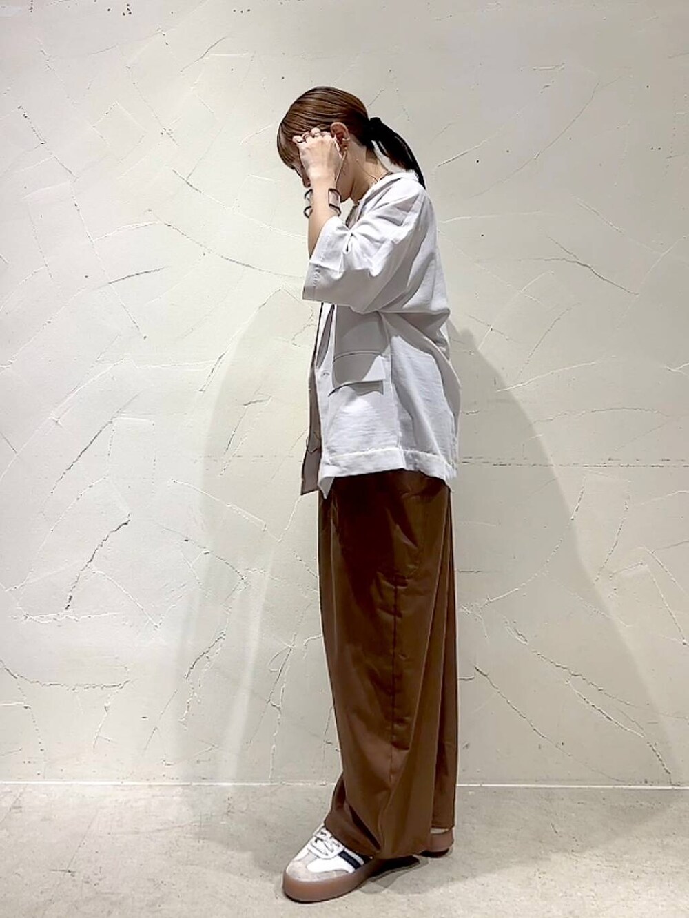 ベージュ系のテーラードジャケット、イエロー系のアナログ腕時計、ベージュ系のネックレスを着用したレディースの春コーディネートの7枚目の写真