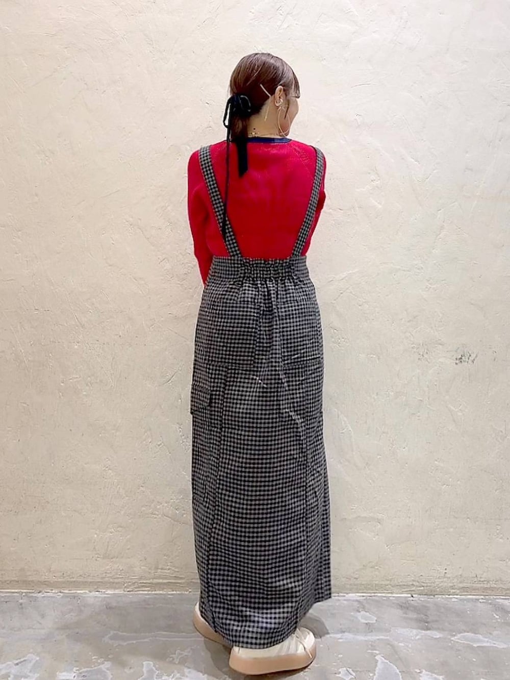 ブラック系のスカート、レッド系のニット/セーターを着用したレディースの秋コーディネートの5枚目の写真