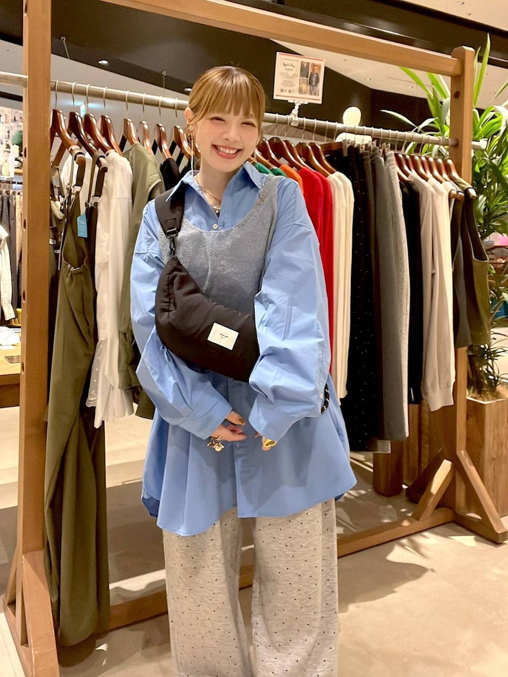ブルー系のシャツ/ブラウス、ブラック系のショルダーバッグ、ブラウン系のチュニックを着用したレディースの秋コーディネートの6枚目の写真