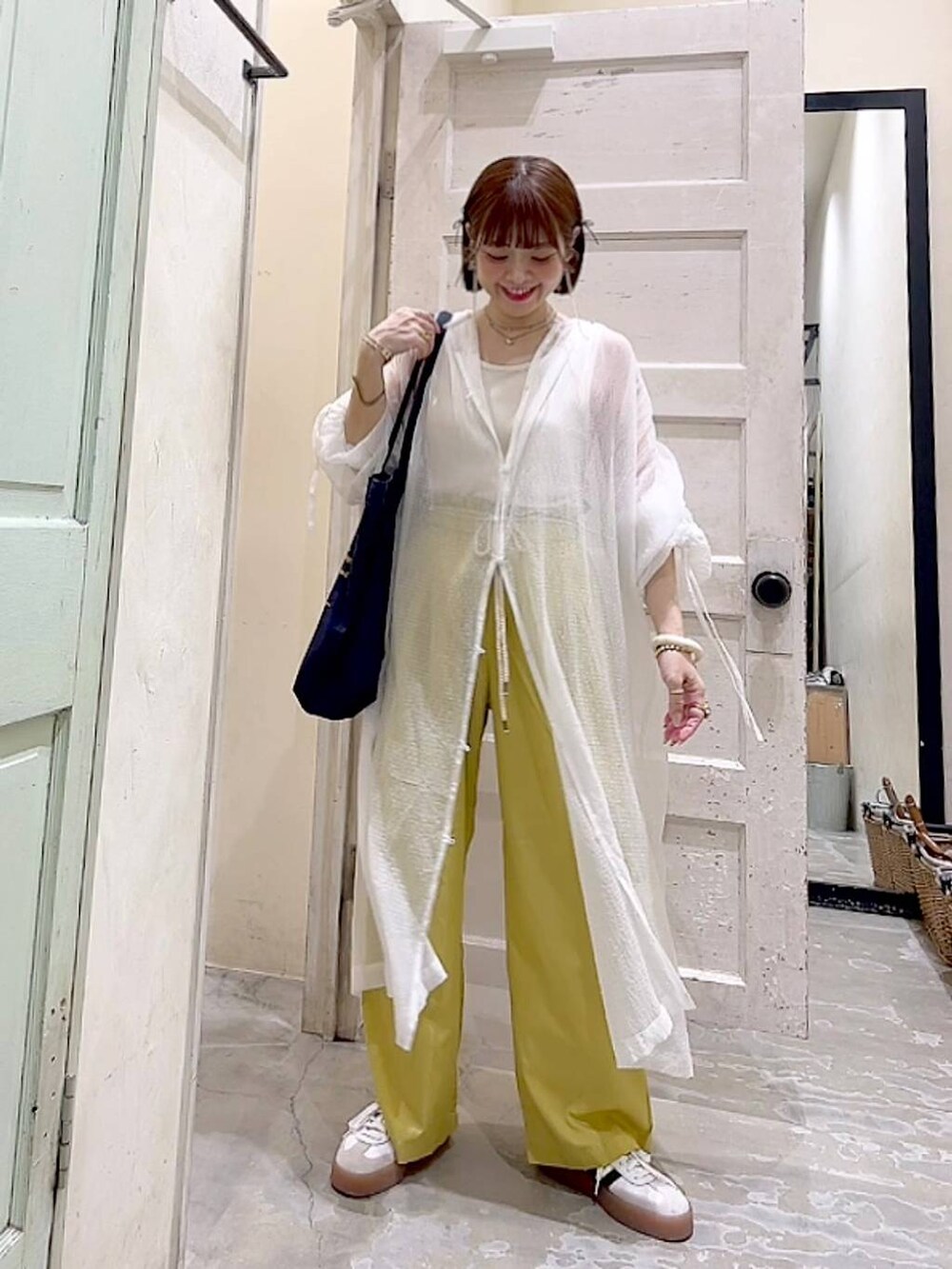 ブルー系のトートバッグ、イエロー系のその他パンツ、ホワイト系のワンピースを着用したレディースの夏コーディネートの6枚目の写真