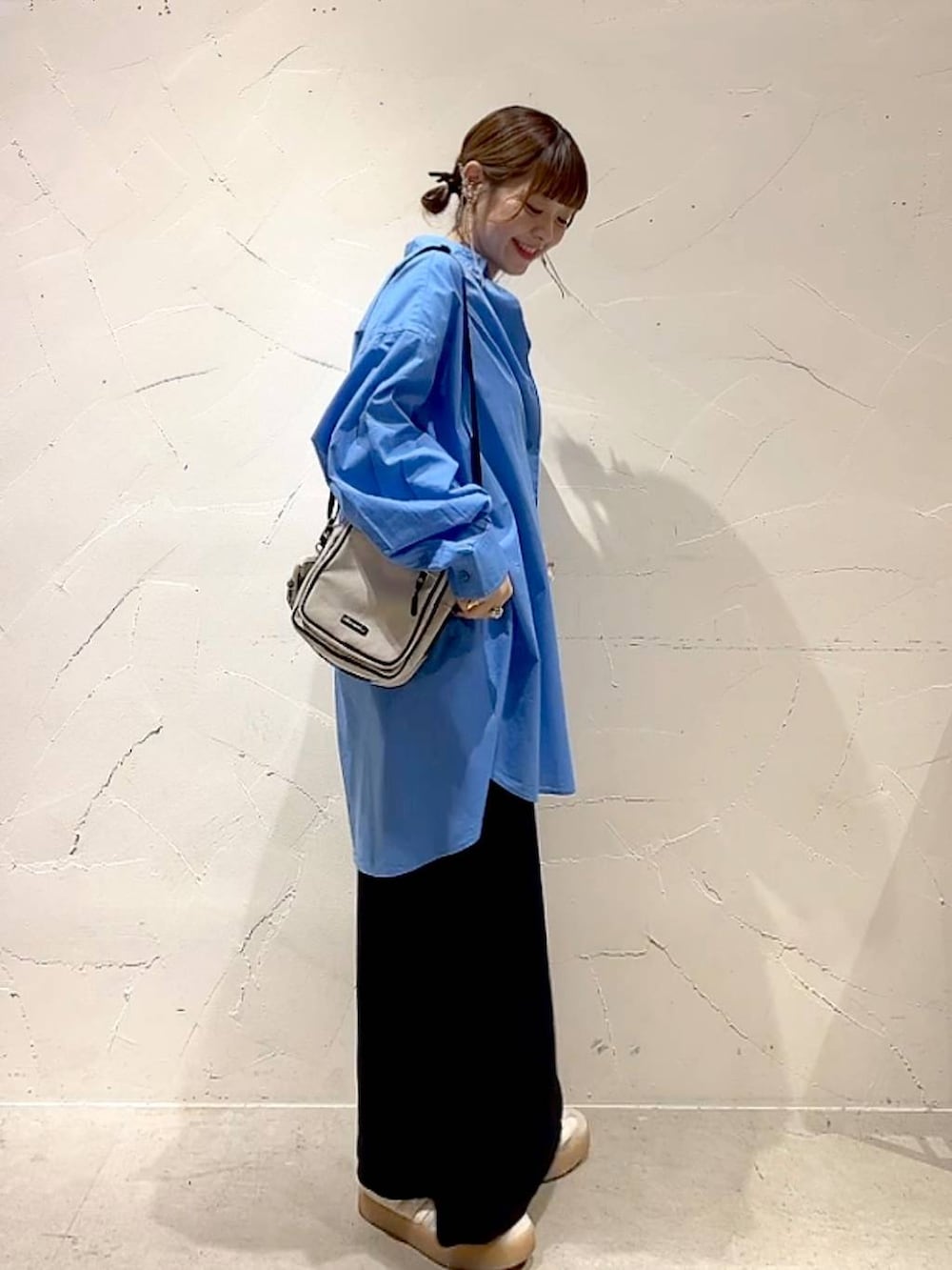 ブラック系のスカート、ブルー系のシャツ/ブラウス、ベージュ系のショルダーバッグを着用したレディースの夏コーディネートの4枚目の写真