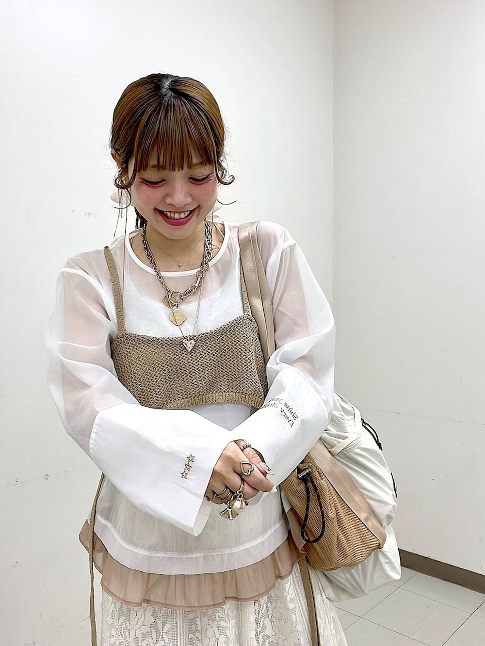 ベージュ系のスニーカー、ベージュ系のトートバッグ、ベージュ系のスカートを着用したレディースの冬コーディネートの5枚目の写真