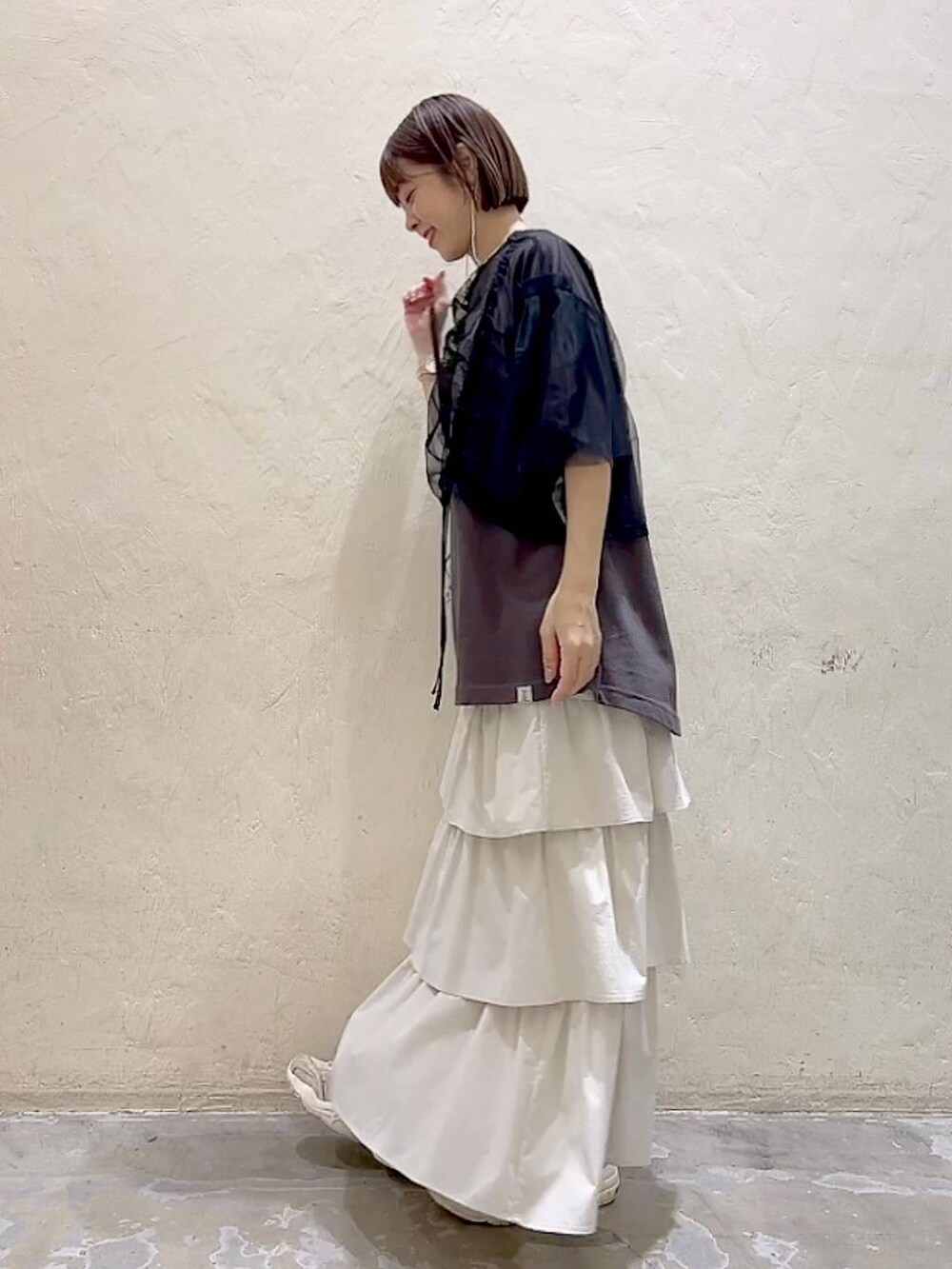 ブラック系のその他トップス、その他のTシャツ/カットソー、ベージュ系のショルダーバッグを着用したレディースの春コーディネートの5枚目の写真