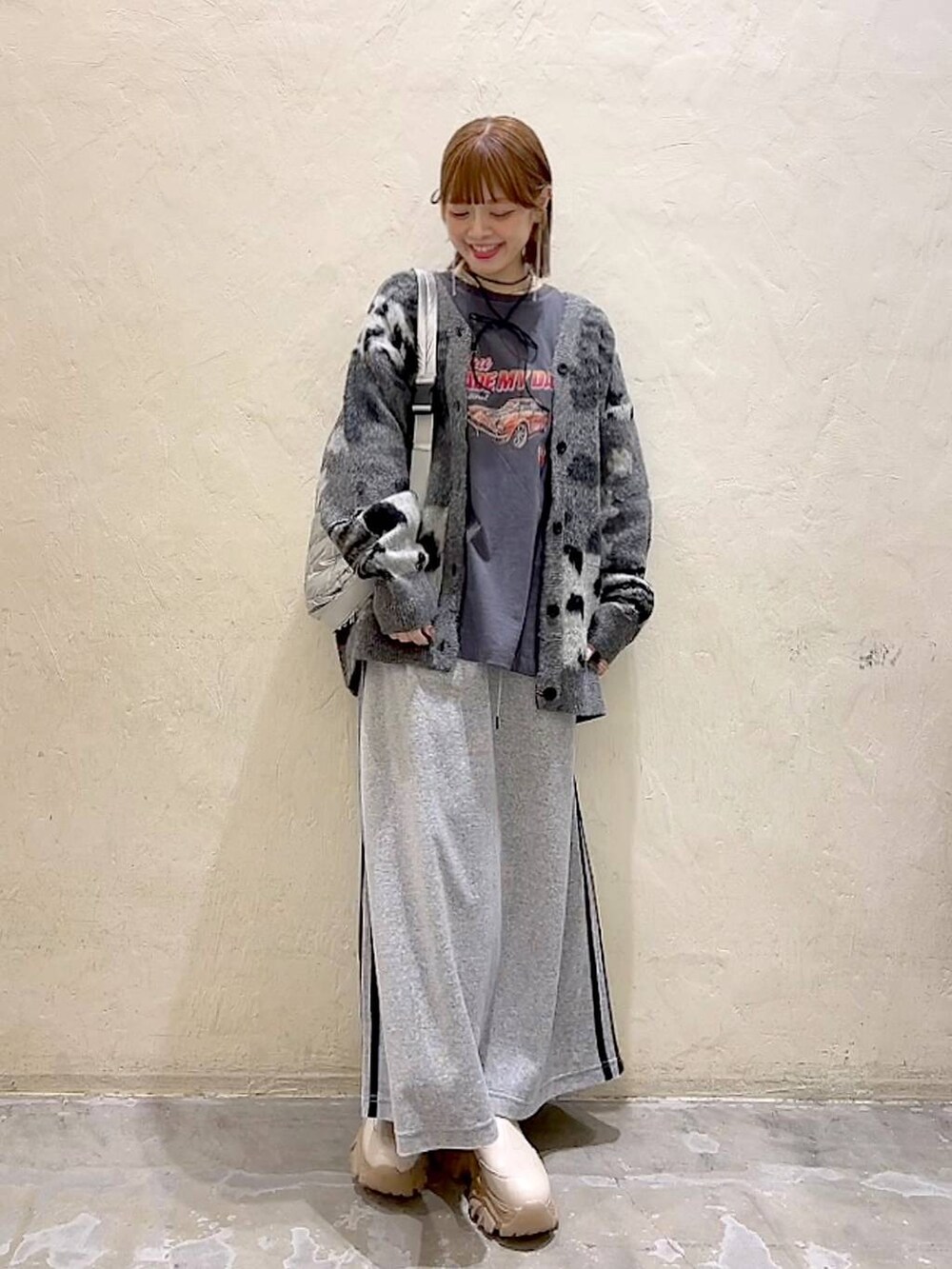 グレー系のTシャツ/カットソー、シルバー系のショルダーバッグ、グレー系のカーディガン/ボレロを着用したレディースの秋コーディネートの8枚目の写真