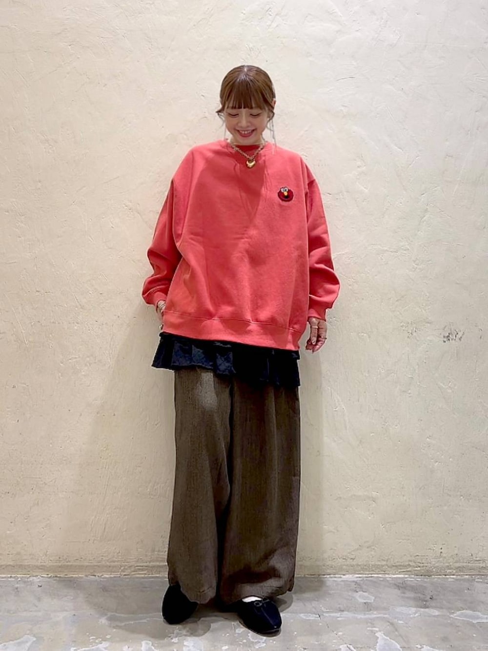 ブラウン系のその他パンツ、ブラック系のパンプス、レッド系のスウェットを着用したレディースの冬コーディネートの3枚目の写真