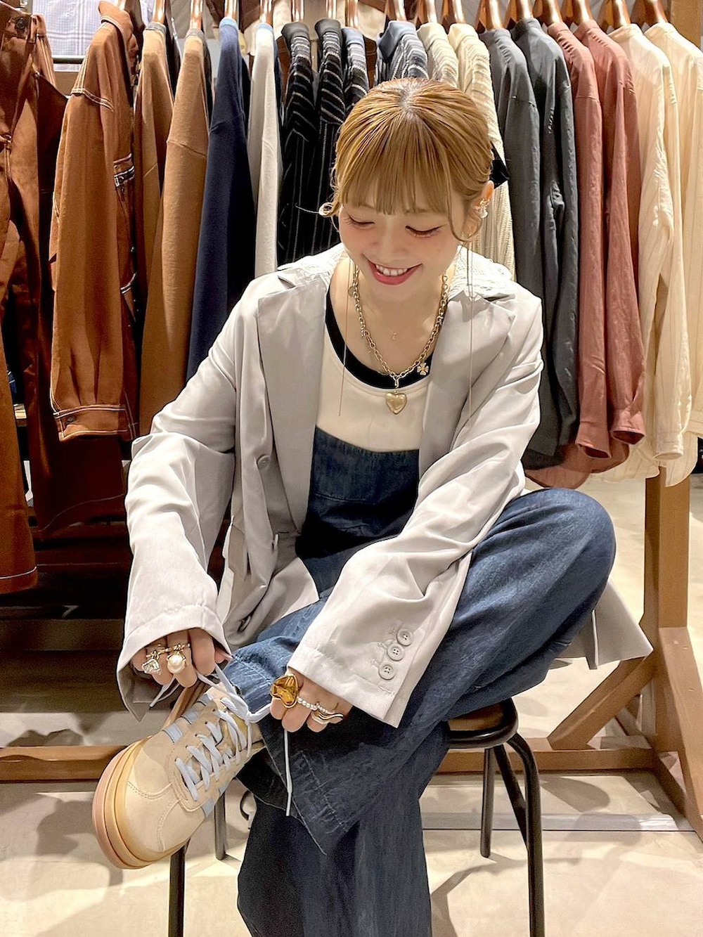 ベージュ系のスニーカー、グレー系のテーラードジャケット、ホワイト系のタンクトップを着用したレディースの春コーディネートの6枚目の写真