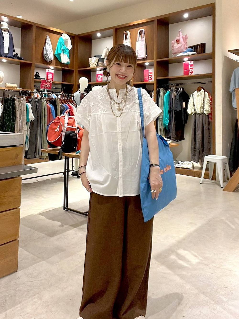ブルー系のトートバッグ、ホワイト系のシャツ/ブラウス、ブラウン系のその他パンツを着用したレディースの夏コーディネートの7枚目の写真