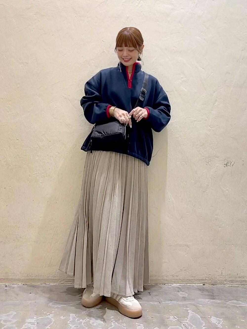 ブルー系のスウェット、ブラック系のショルダーバッグ、グレー系のスカートを着用したレディースの冬コーディネートの6枚目の写真