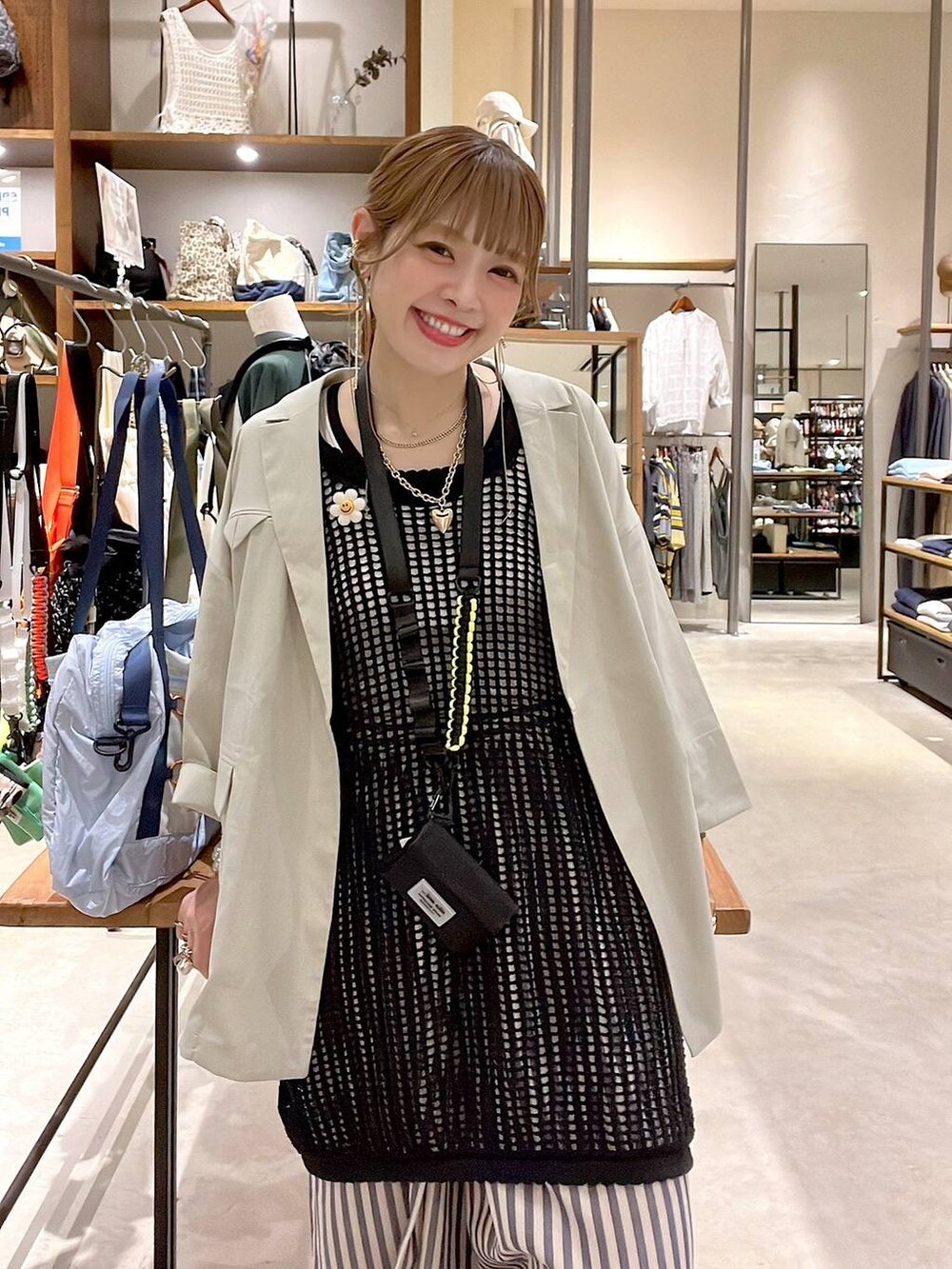 ベージュ系のテーラードジャケット、ブルー系のその他パンツ、ブラック系のワンピースを着用したレディースの春コーディネートの4枚目の写真