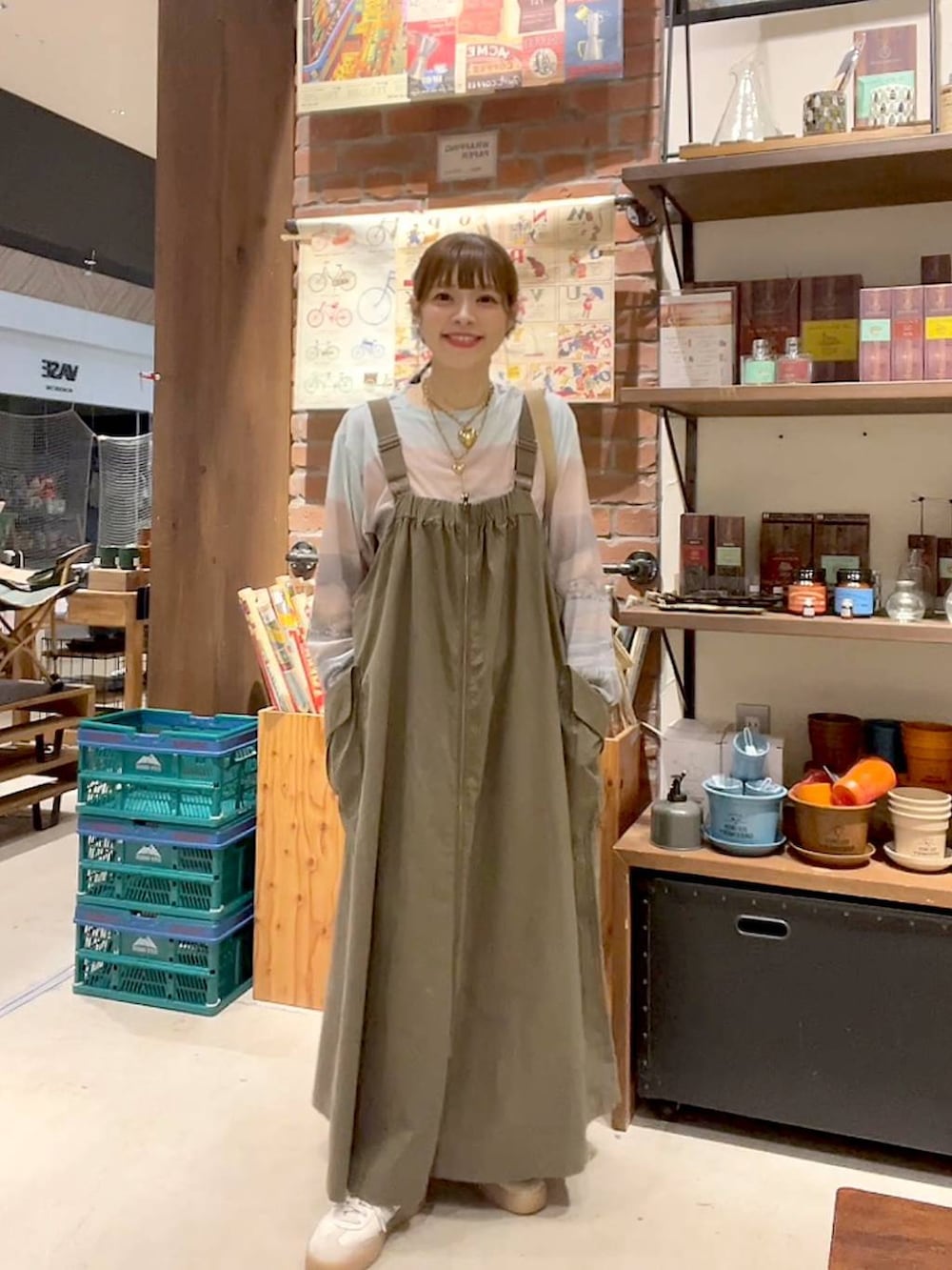 ベージュ系のTシャツ/カットソー、ベージュ系のショルダーバッグ、グリーン系のジャンパースカートを着用したレディースの夏コーディネートの6枚目の写真