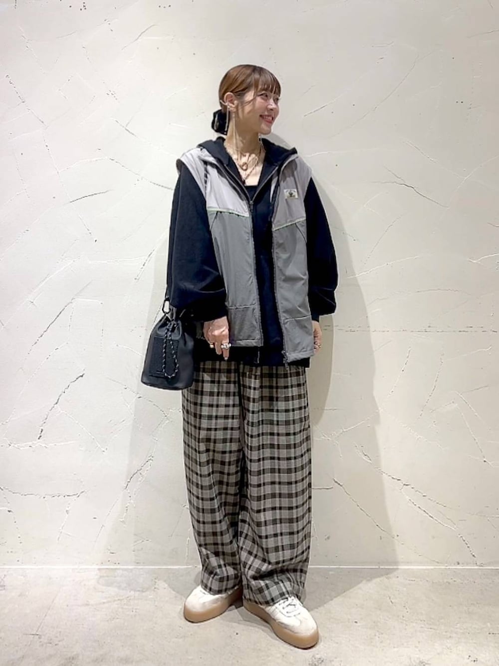 ブラック系のショルダーバッグ、ブラウン系のその他パンツ、イエロー系のネックレスを着用したレディースの秋コーディネートの8枚目の写真