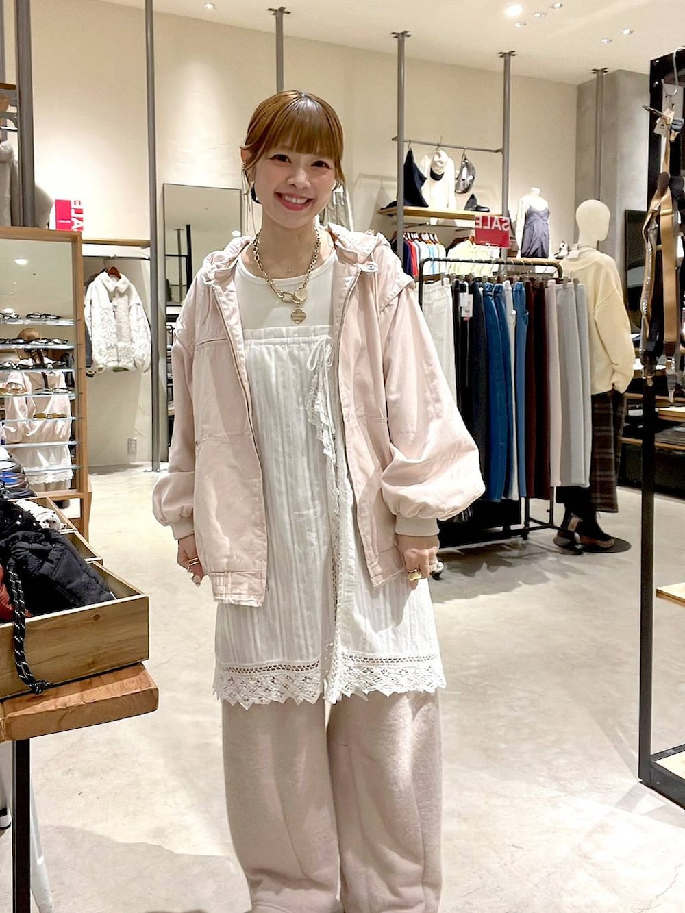 ピンク系のブルゾン、ホワイト系のスカート、ベージュ系のスウェットパンツを着用したレディースの冬コーディネートの2枚目の写真