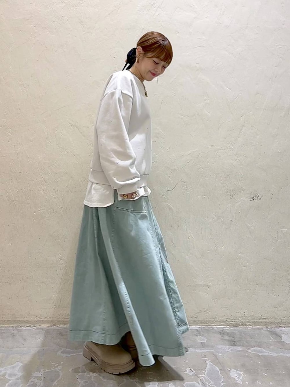 ホワイト系のTシャツ/カットソー、グリーン系のスカート、ホワイト系のその他トップスを着用したレディースの冬コーディネートの3枚目の写真