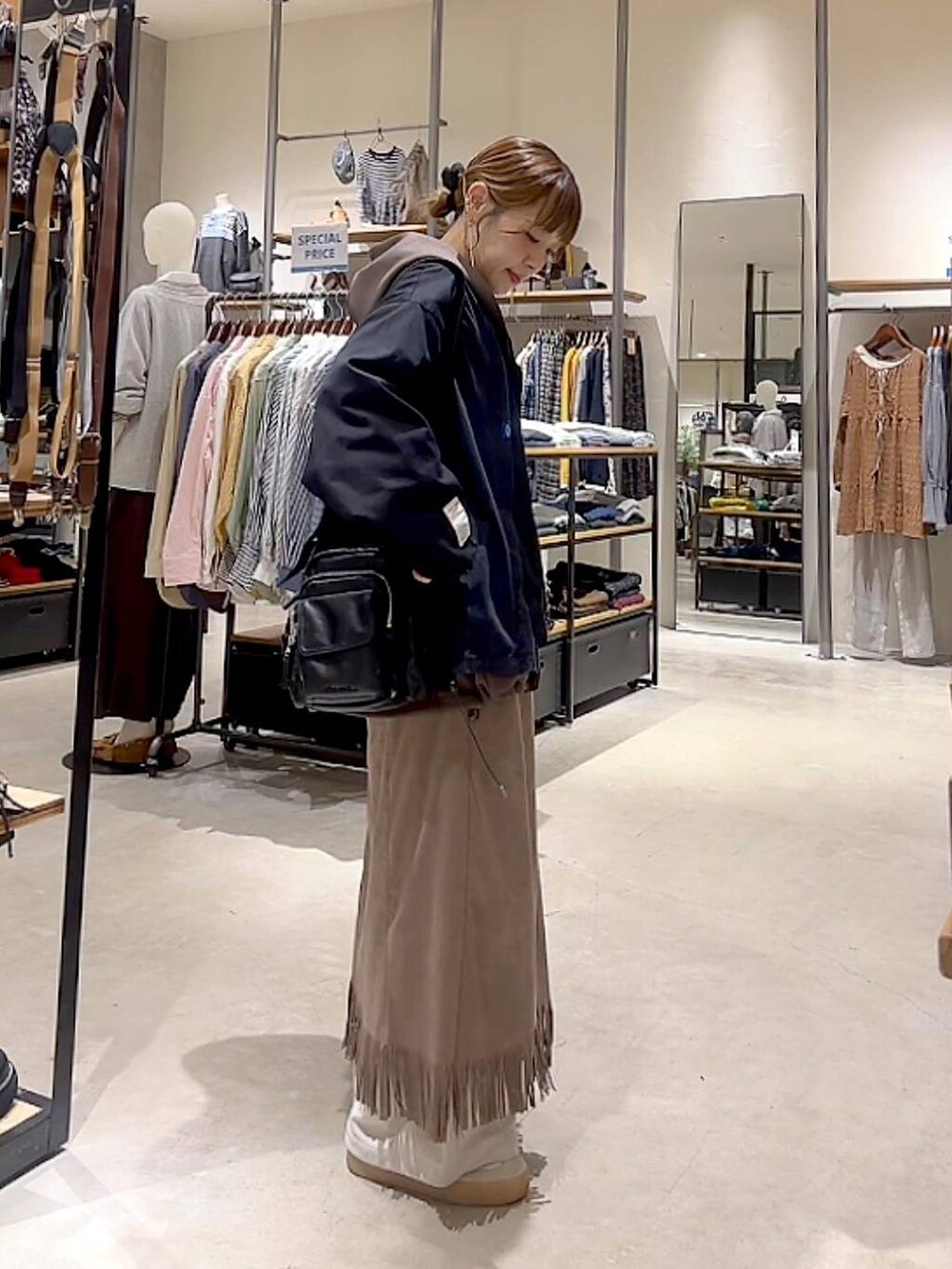 ブラウン系のスカート、ブラウン系のパーカー、ベージュ系のその他パンツを着用したレディースの秋コーディネートの4枚目の写真