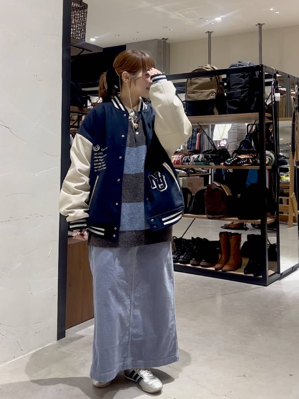 ゴールド系のスニーカー、ブルー系のスカート、ブルー系のブルゾンを着用したレディースの秋コーディネートの4枚目の写真