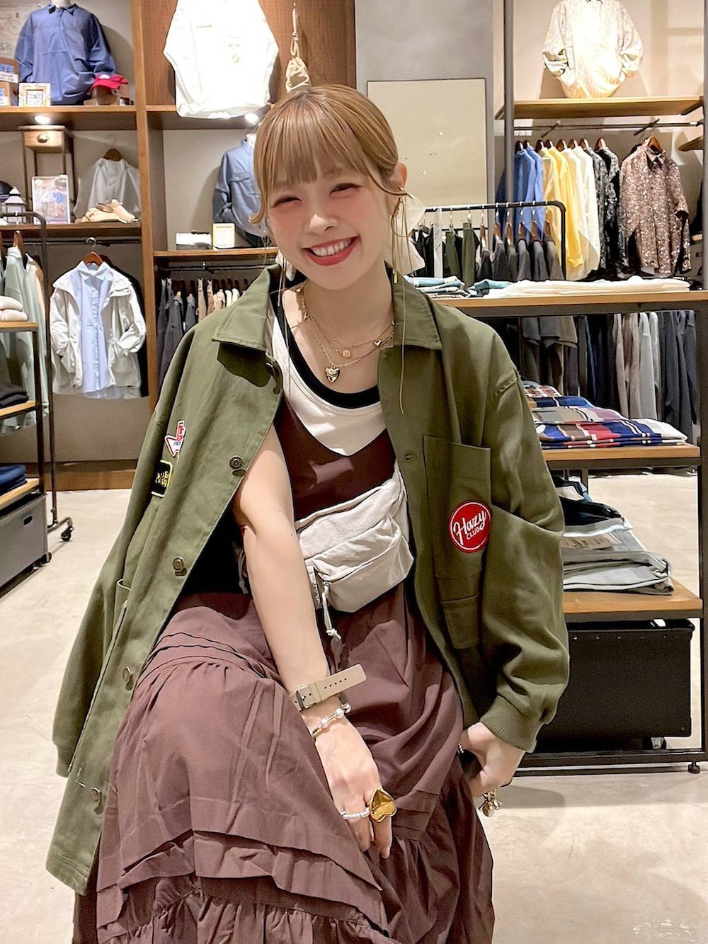 ピンク系のデニムパンツ、ホワイト系のタンクトップ、イエロー系のブレスレットを着用したレディースの春コーディネートの3枚目の写真