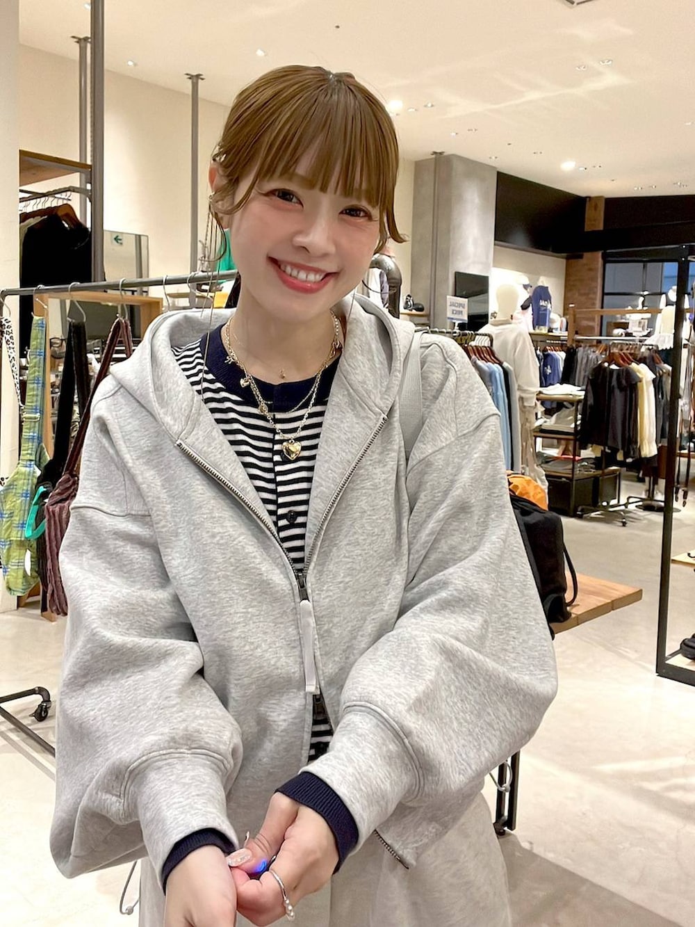 グレー系のスウェットパンツ、グレー系のパーカー、ブルー系のカーディガン/ボレロを着用したレディースの冬コーディネートの2枚目の写真