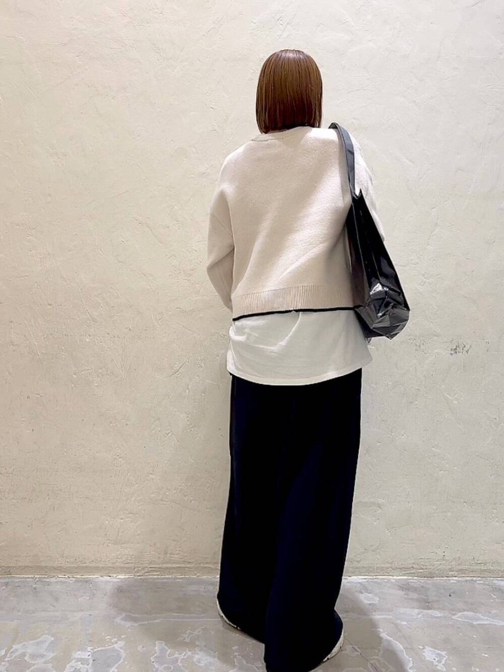 ホワイト系のTシャツ/カットソー、ブラック系のその他パンツ、ベージュ系のニット/セーターを着用したレディースの冬コーディネートの4枚目の写真