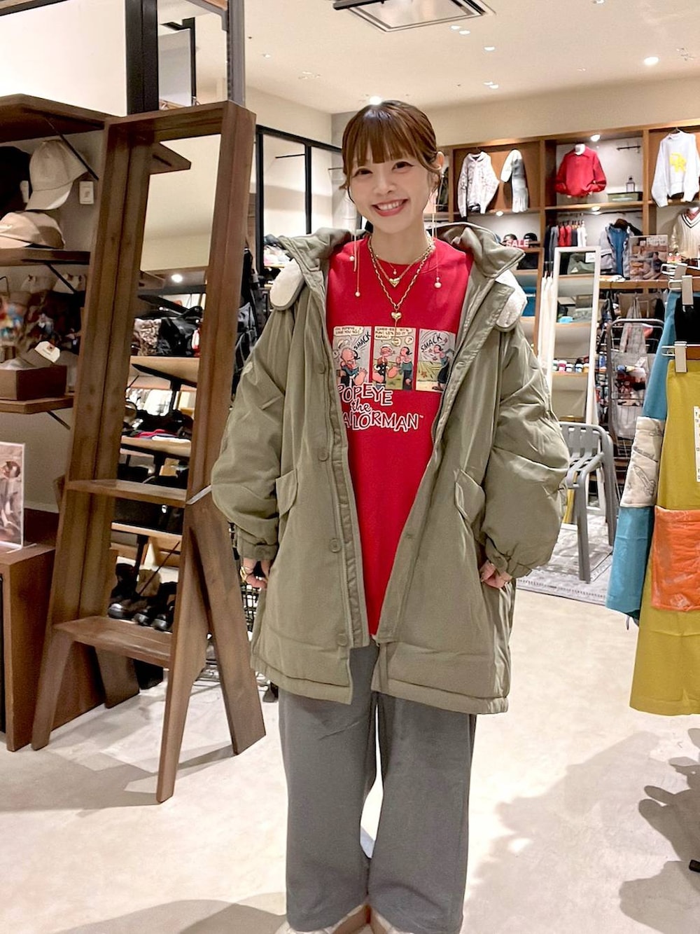 グリーン系のブルゾン、グレー系のその他パンツ、レッド系のスウェットを着用したレディースの冬コーディネートの7枚目の写真