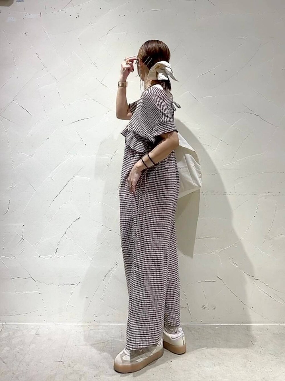 ベージュ系のトートバッグ、イエロー系のアナログ腕時計、ゴールド系のネックレスを着用したレディースの春コーディネートの6枚目の写真