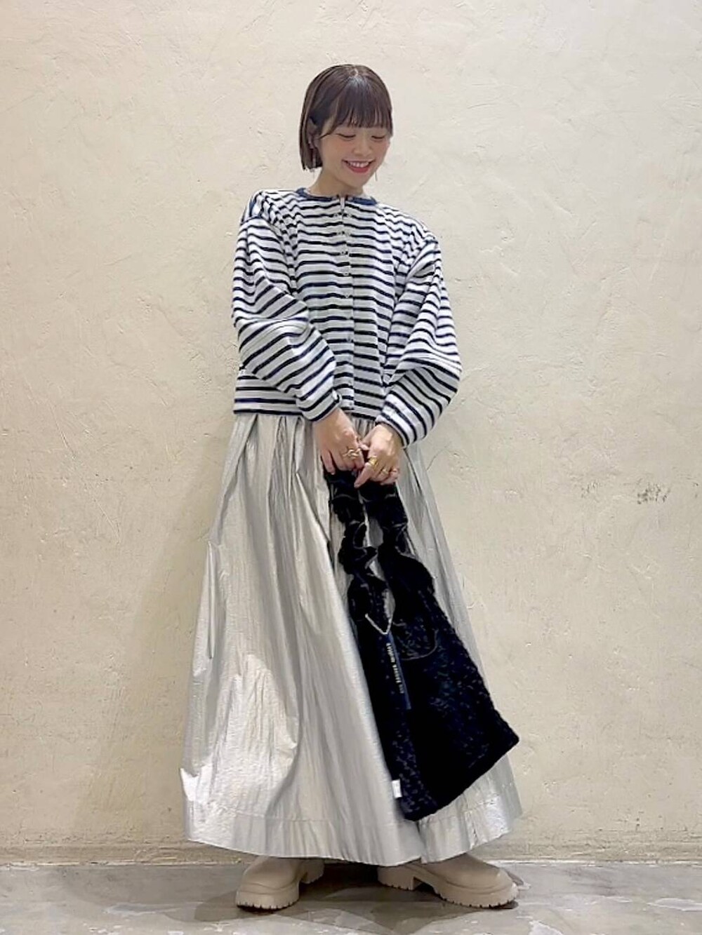 ベージュ系のブーツ、ブラック系のトートバッグ、ホワイト系のTシャツ/カットソーを着用したレディースの冬コーディネートの8枚目の写真