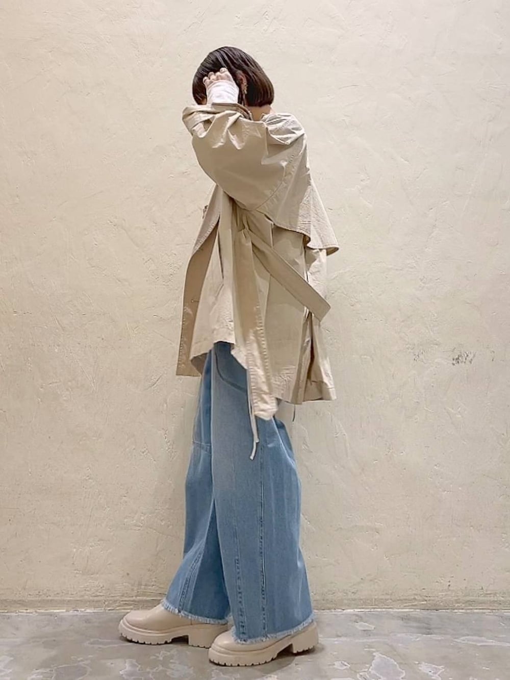 グレー系のキャミソール、ベージュ系のベスト、ベージュ系のブーツを着用したレディースの冬コーディネートの3枚目の写真