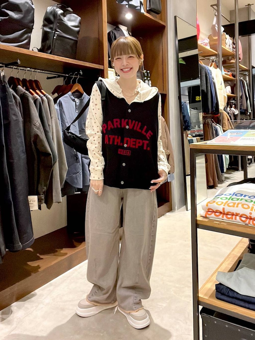 ピンク系のデニムパンツ、ベージュ系のスニーカー、ブラック系のボディバッグ/ウエストポーチを着用したレディースの冬コーディネートの4枚目の写真