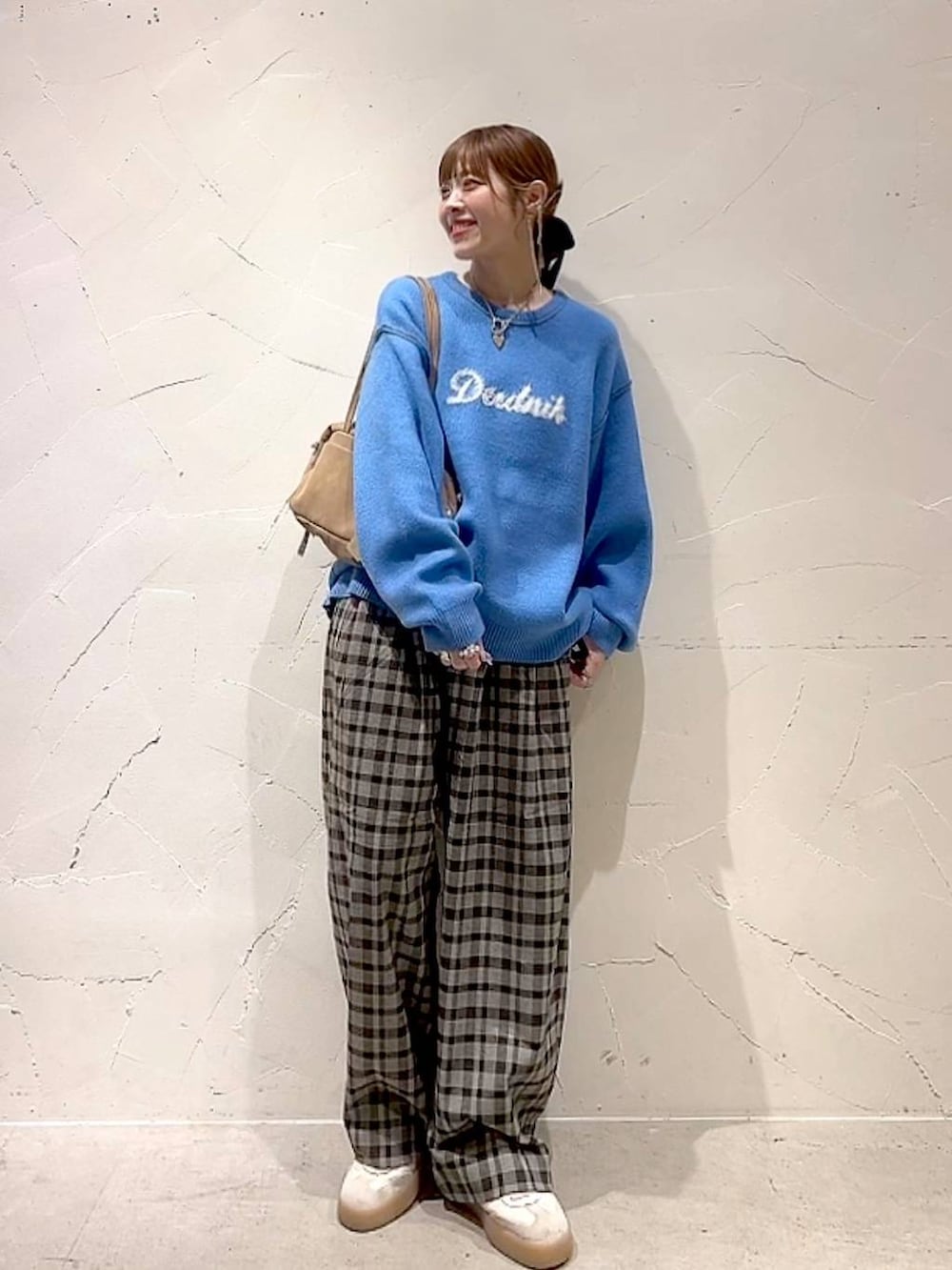 ブラウン系のその他パンツ、ブルー系のニット/セーター、ベージュ系のボストンバッグを着用したレディースの秋コーディネートの2枚目の写真