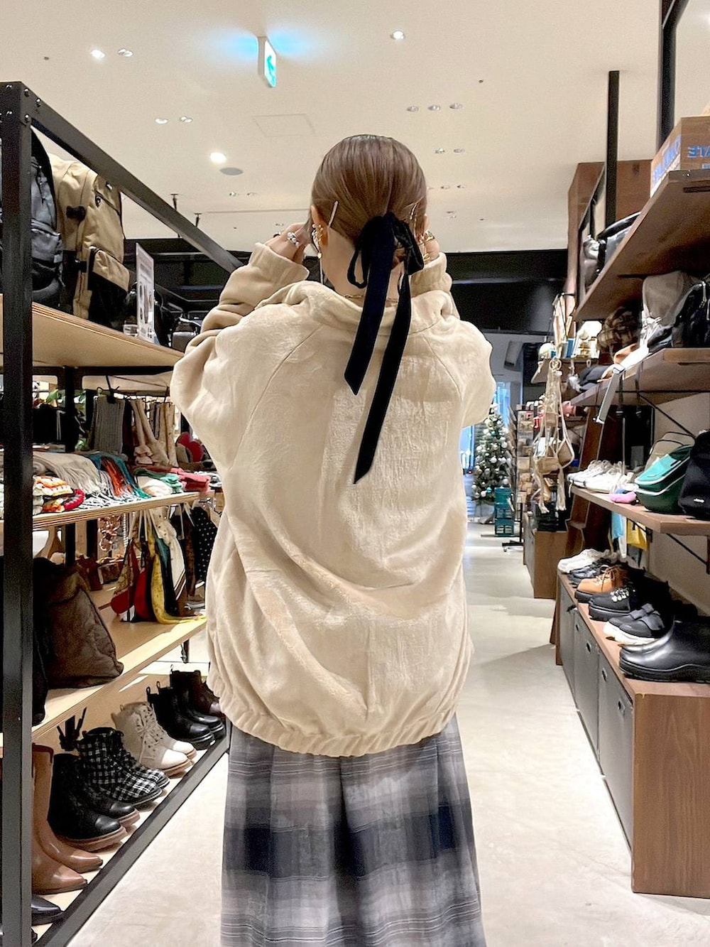 ゴールド系のスニーカー、ベージュ系のブルゾン、イエロー系のネックレスを着用したレディースの秋コーディネートの4枚目の写真