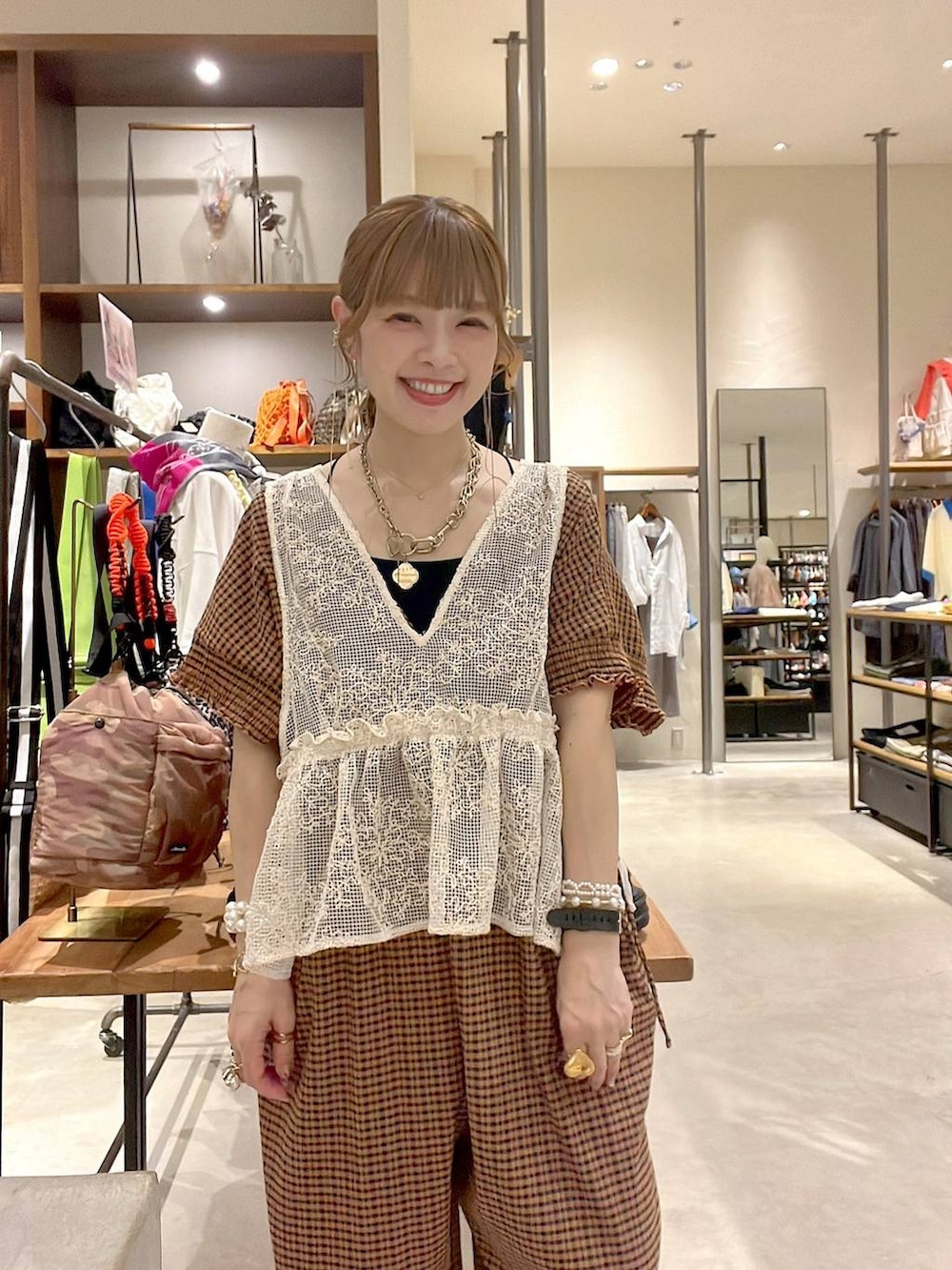ベージュ系のショルダーバッグ、イエロー系のつなぎ/オールインワン、ブラック系のキャミソールを着用したレディースの春コーディネートの3枚目の写真