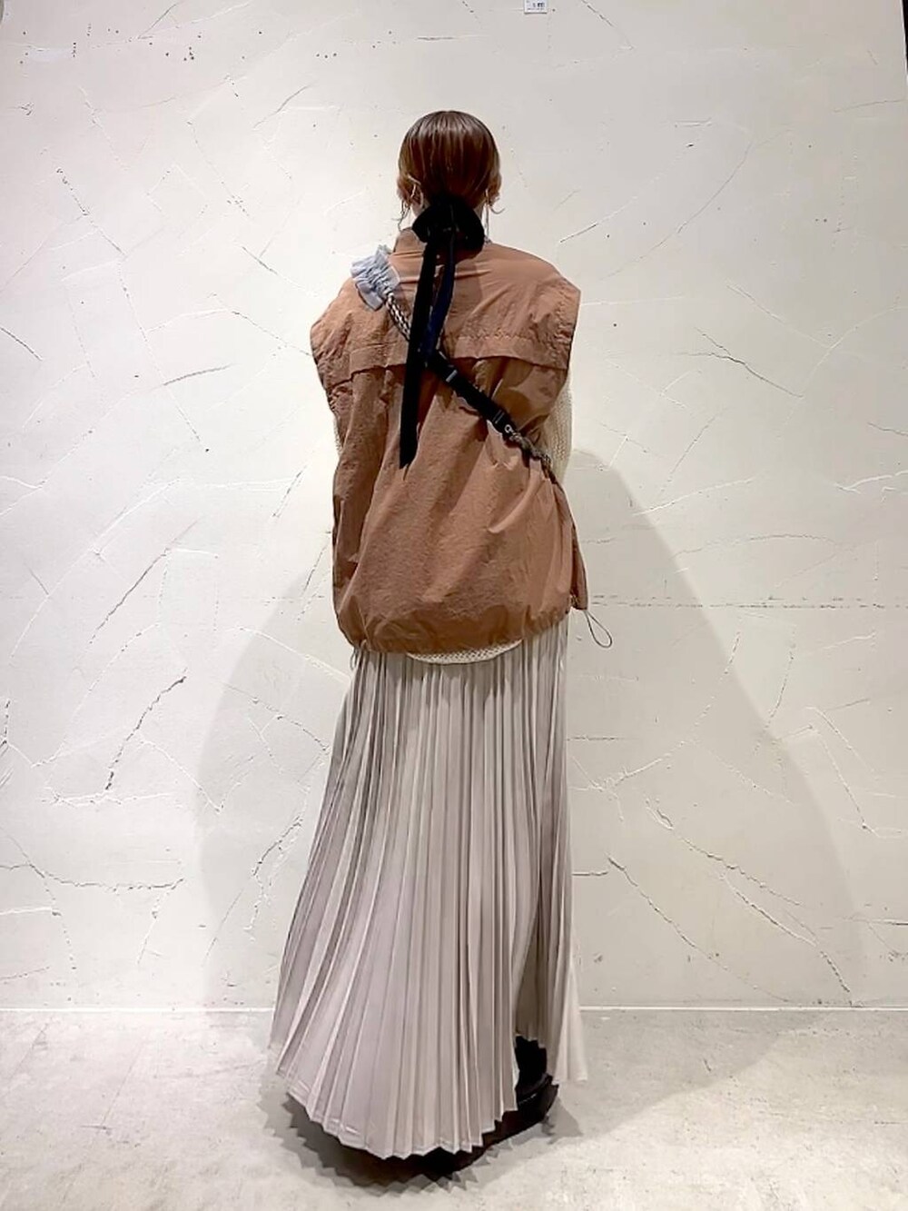 ブラウン系のブルゾン、ブラック系のドレスシューズ、ベージュ系のTシャツ/カットソーを着用したレディースの秋コーディネートの5枚目の写真