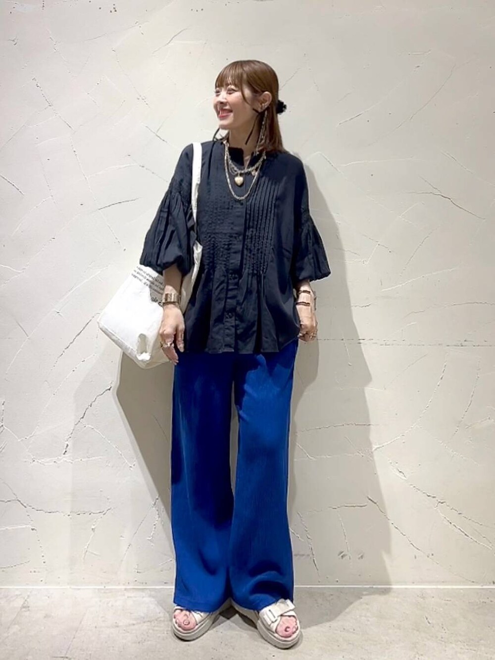 ベージュ系のトートバッグ、ブラック系のシャツ/ブラウス、ブルー系のその他パンツを着用したレディースの春コーディネートの2枚目の写真