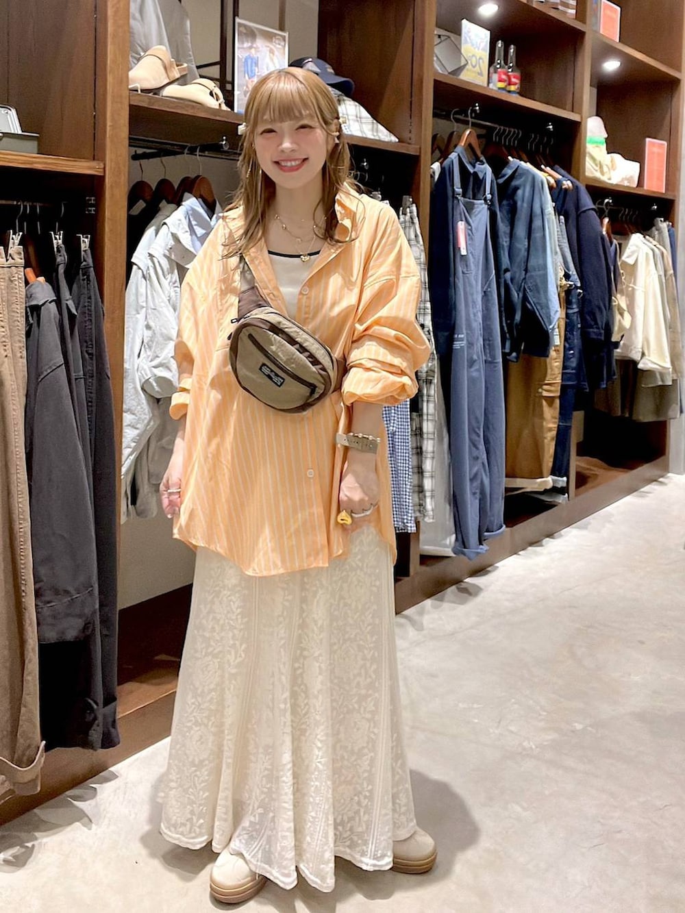 ベージュ系のスニーカー、ベージュ系のボディバッグ/ウエストポーチ、ベージュ系のキャミソールを着用したレディースの春コーディネートの3枚目の写真