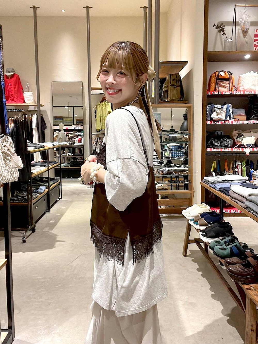 ホワイト系のタンクトップ、ベージュ系のスカート、ブラウン系のキャミソールを着用したレディースの夏コーディネートの6枚目の写真