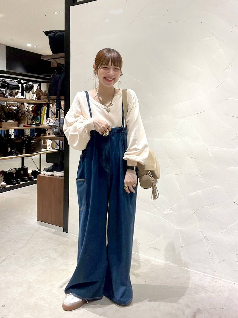 ベージュ系のショルダーバッグ、ブラック系のアナログ腕時計を着用したレディースの秋コーディネートの2枚目の写真