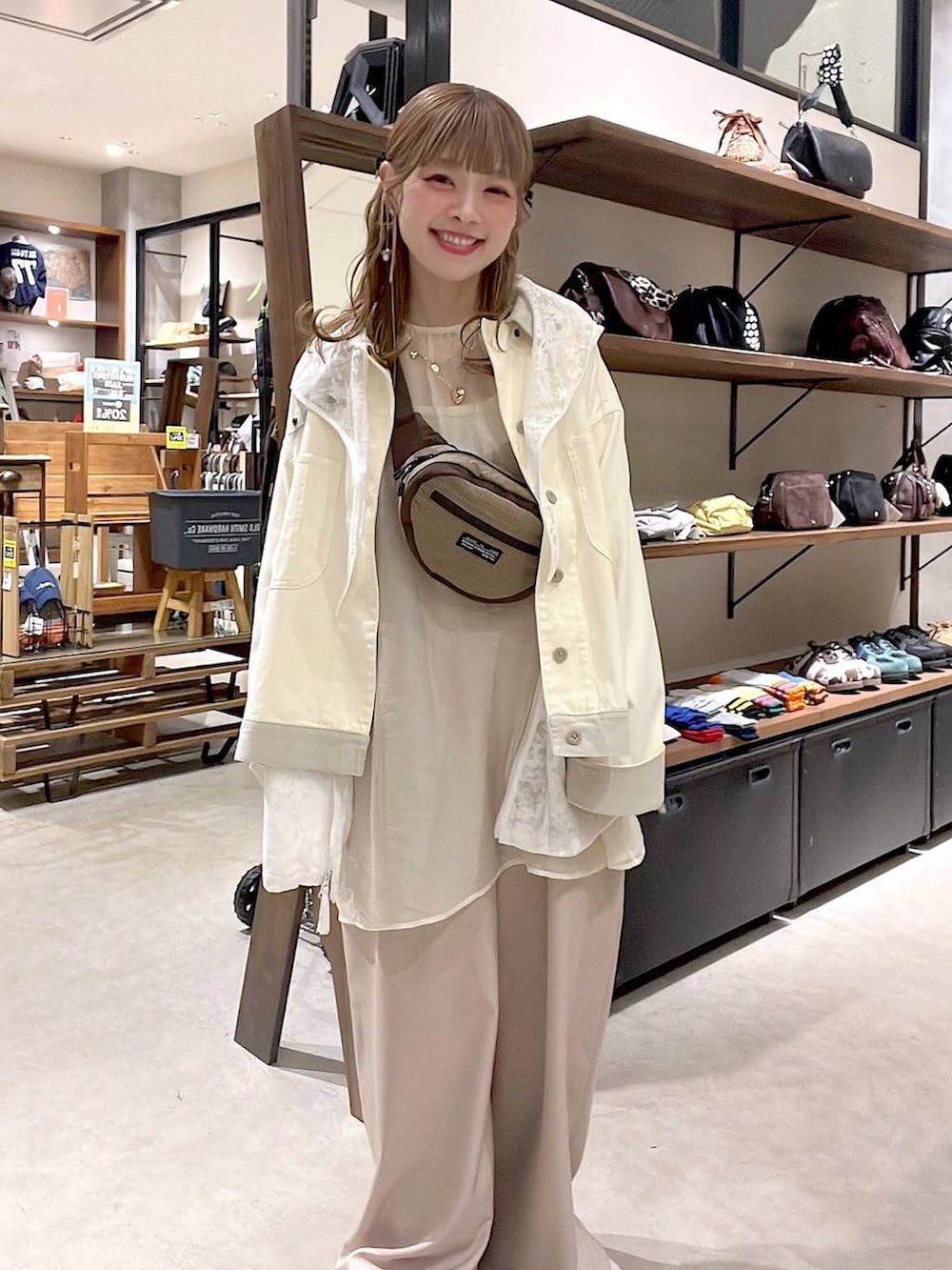 ホワイト系のベスト、ベージュ系のボディバッグ/ウエストポーチ、ホワイト系のブルゾンを着用したレディースの春コーディネートの3枚目の写真